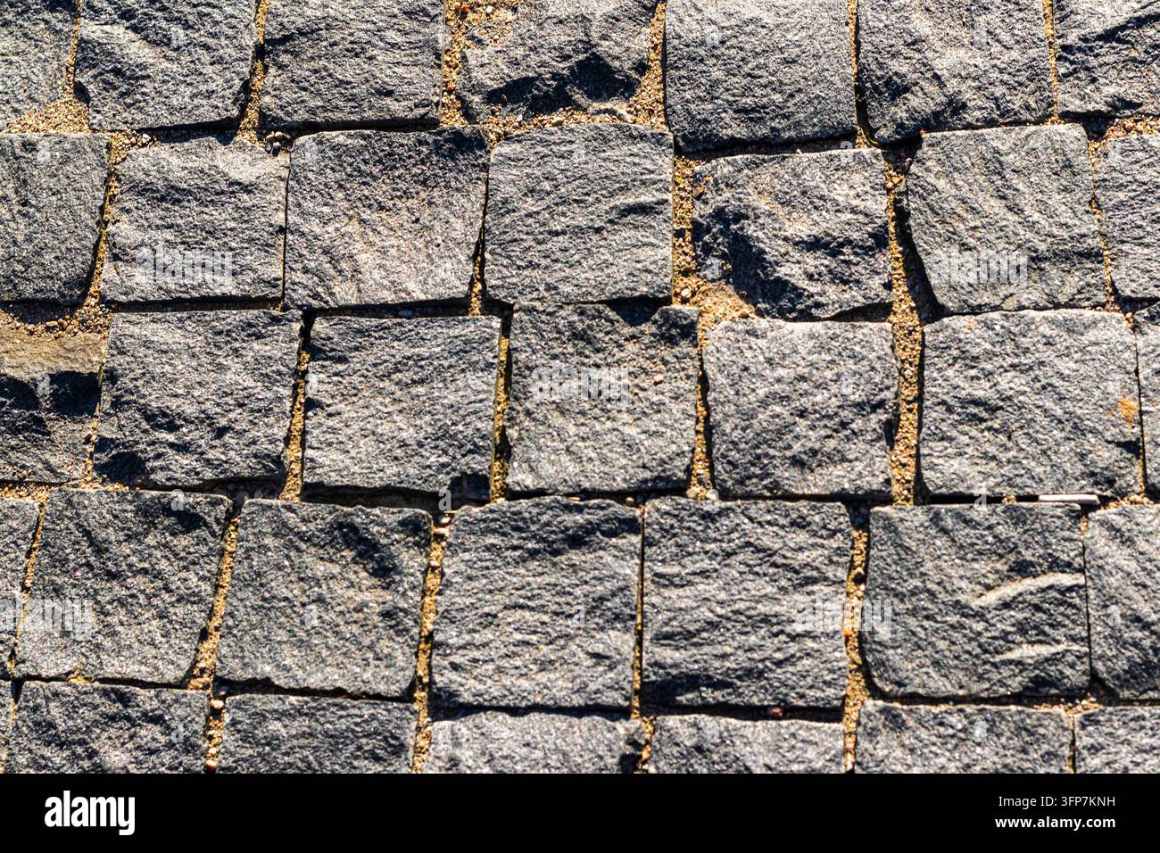 Sfondo a texture ad angolo alto di blocchi di ciottoli quadrati in granito Foto Stock