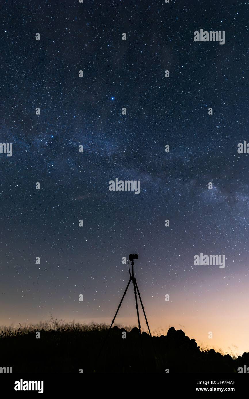 Fotocamera su treppiede che cattura il cielo notturno stellato mozzafiato e la Via Lattea visibile Foto Stock