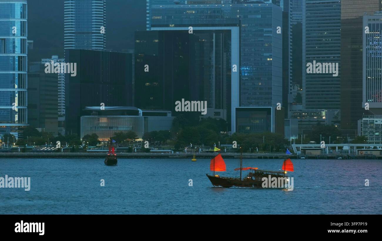 Junk tradizionale cinese con vele rosse nel Victoria Harbour di notte, Hong Kong Foto Stock