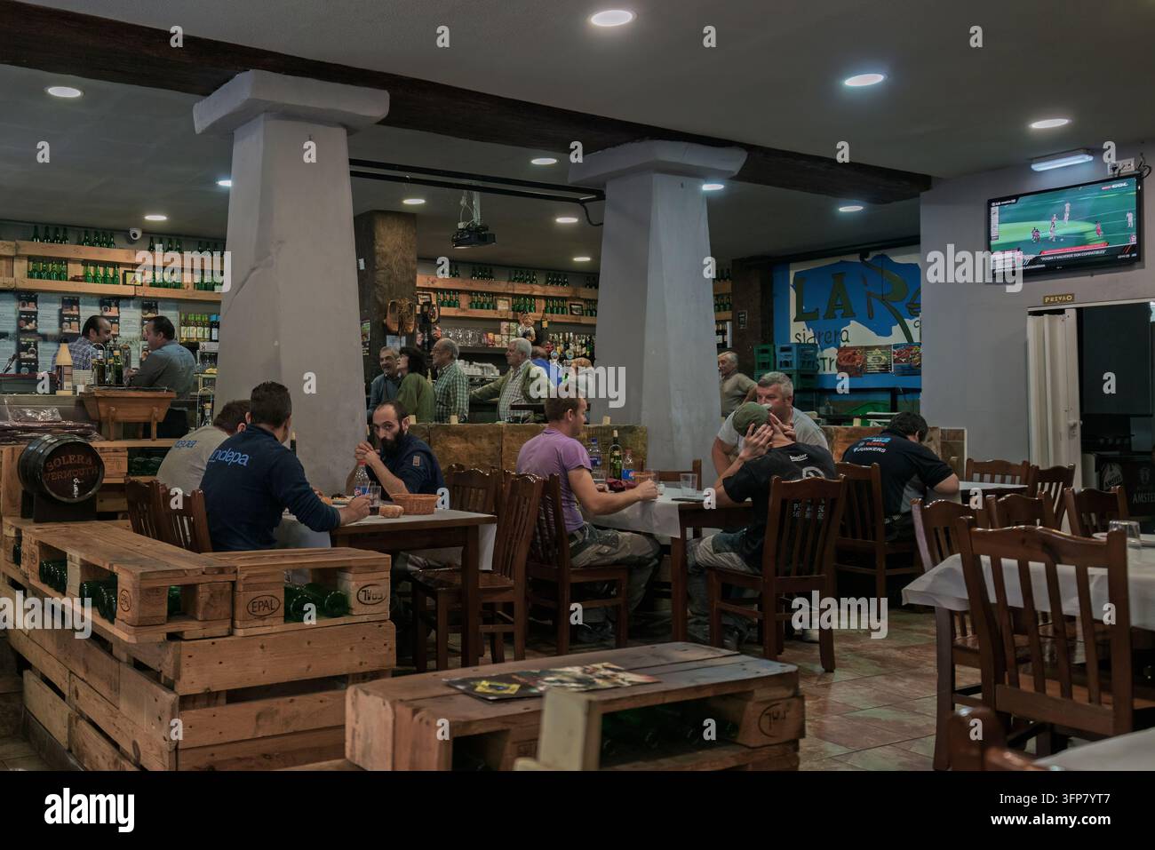 Interno di una sidrería tradizionale spagnola ad Avilés, Principato delle Asturie, che mostra i clienti che gustano il sidro e socializzano in un'atmosfera rustica. Foto Stock