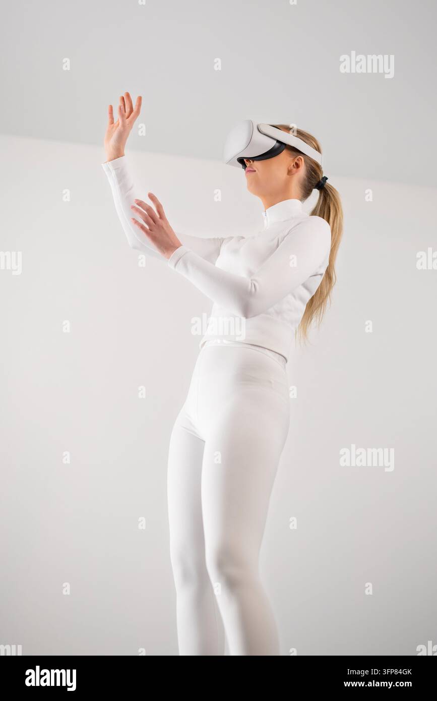 Donna in bianco che utilizza la realtà virtuale Foto Stock