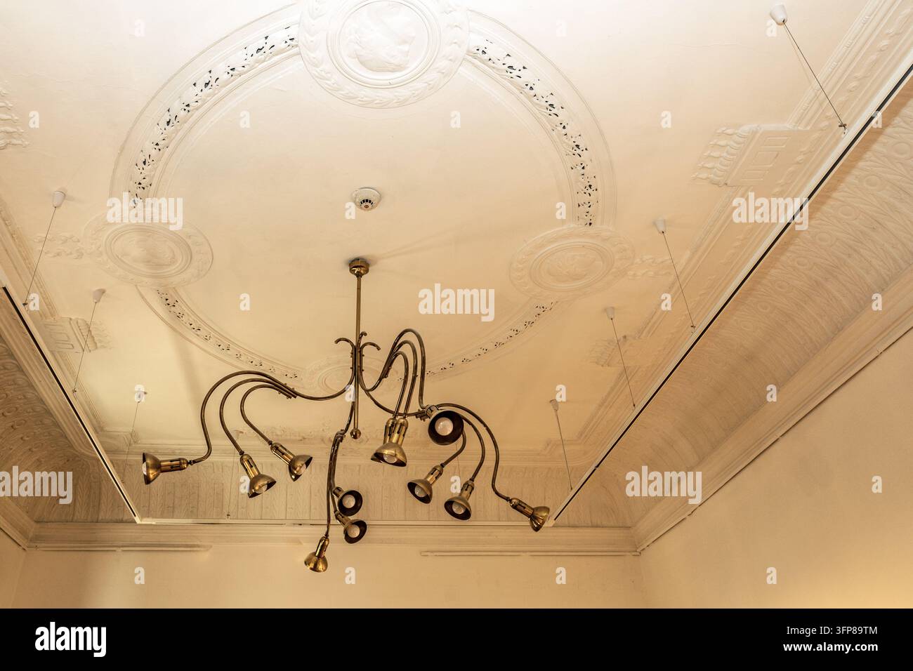 Soffitto in stucco ornato con un lampadario decorativo in ottone a più bracci, Galleria d'Arte Contemporanea, Palazzo Raichle, Art Nouveau, Subotica, Serbia Foto Stock