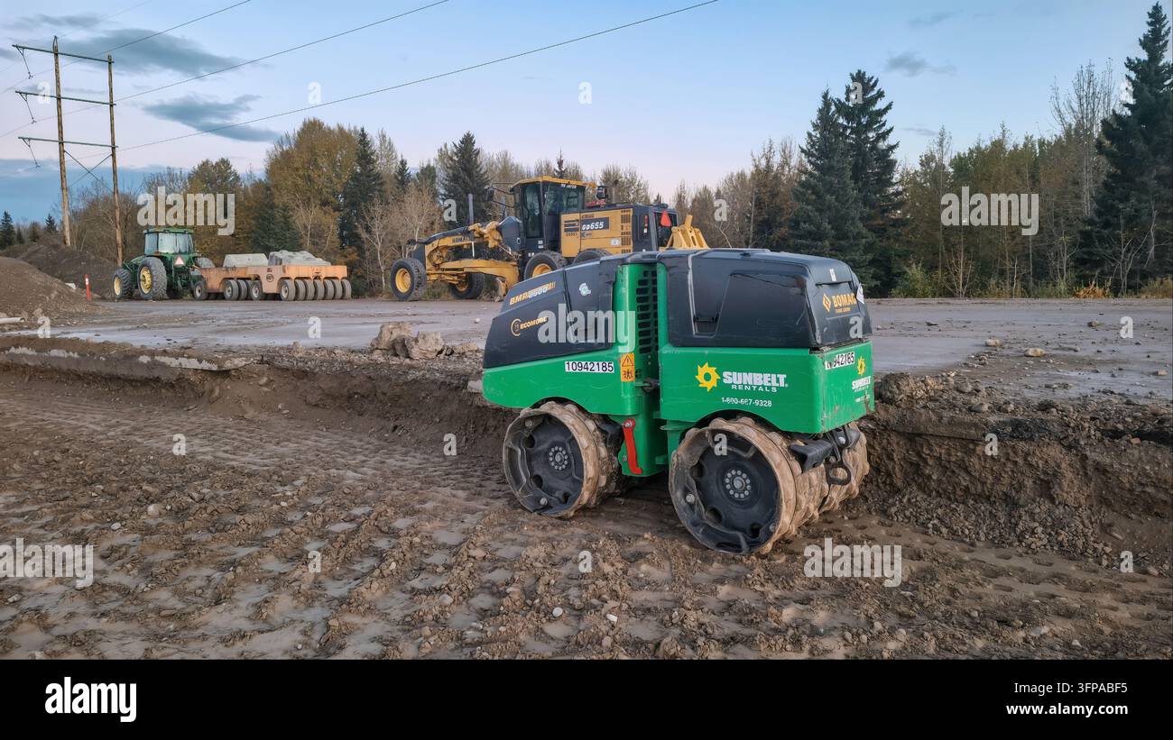 CALGARY, CANADA - 26 SETTEMBRE 2026: Un rullo compatitore per trincee multiuso radiocomandato Bomag BMP 8500 verde e nero con Sunbelt Renta Foto Stock