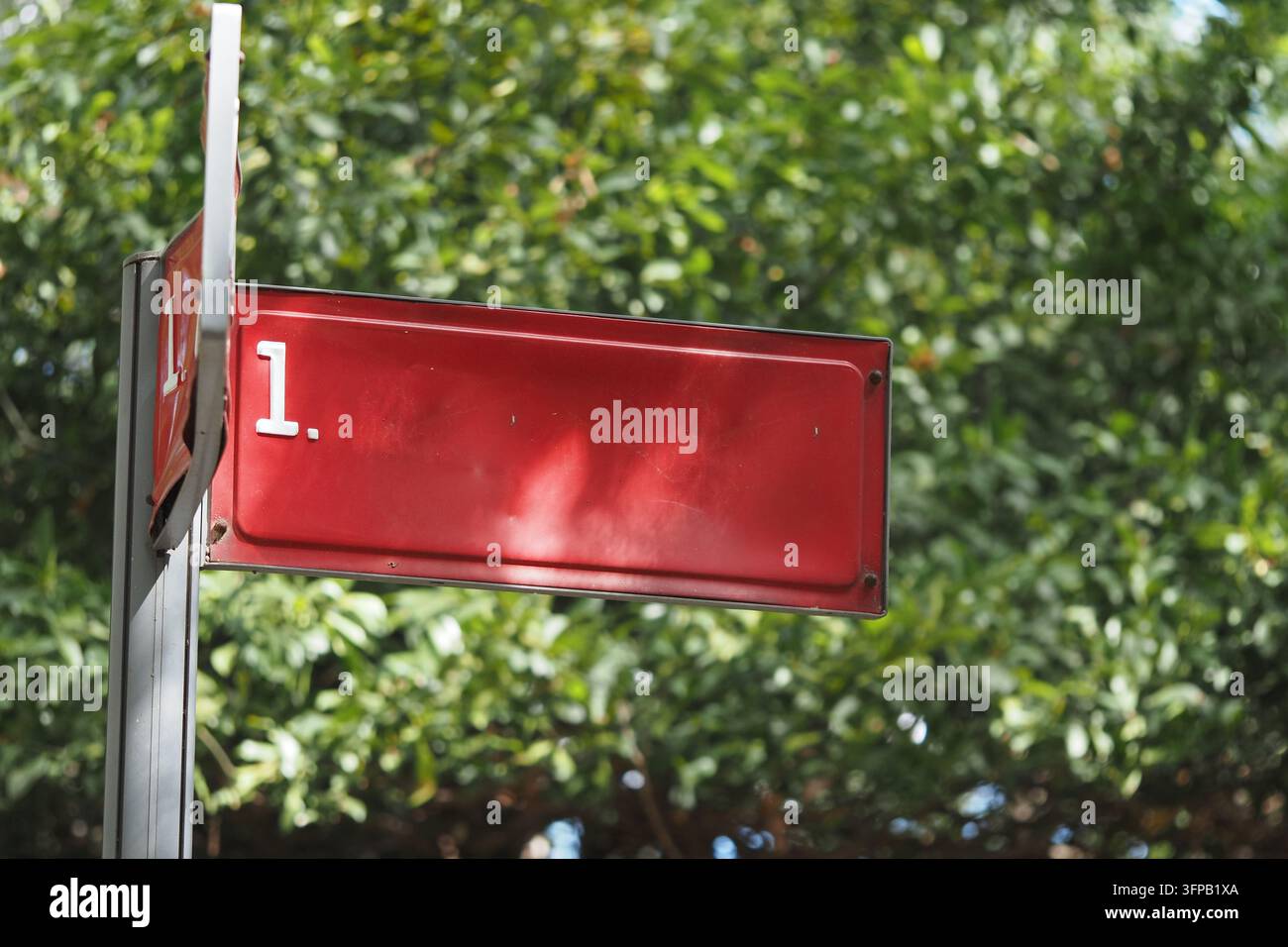 Un cartello che indica la prima fermata situata all'interno di un'area verde Foto Stock