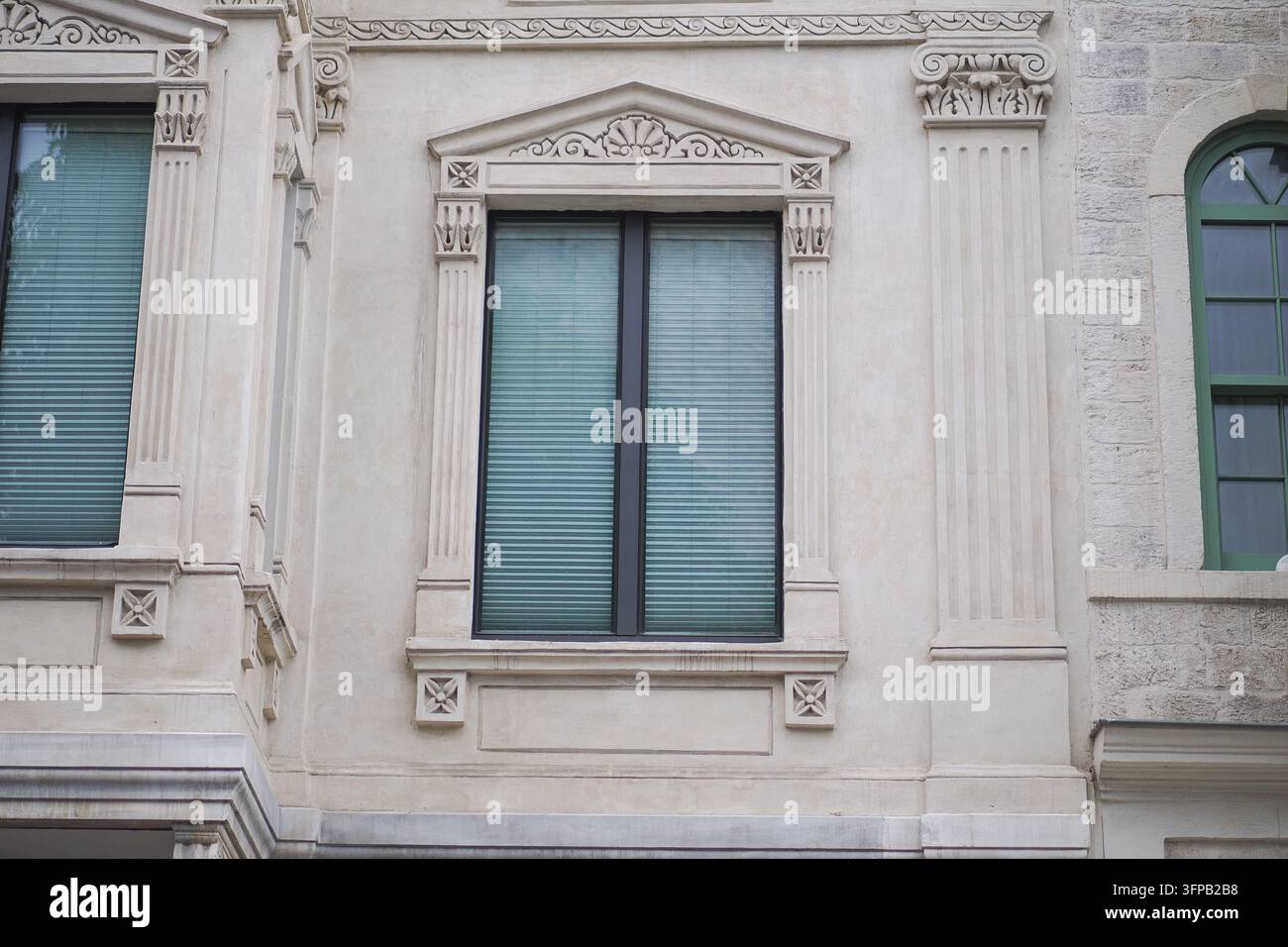 Facciata di edificio con finestre ed elementi decorativi in un contesto cittadino Foto Stock