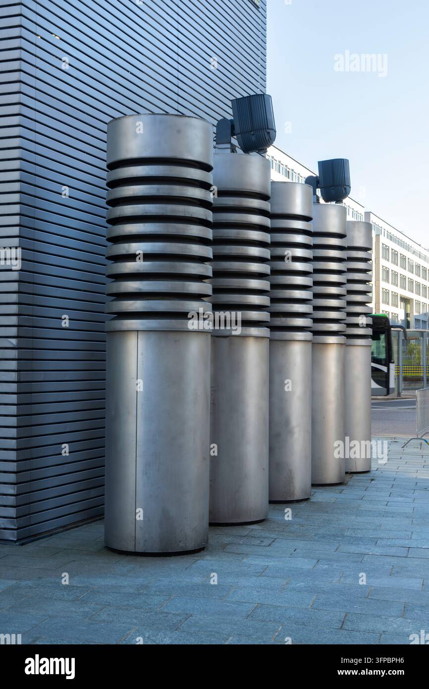 Sankt Polten, Austria. 28 settembre 2026. Una fila di strutture cilindriche identiche con cime scanalate si trova davanti a un muro metallico ondulato. T Foto Stock