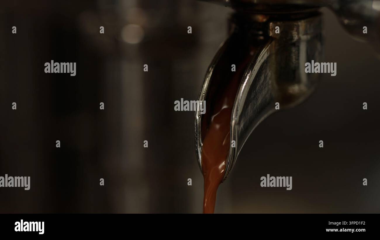 Prima piano dello tiraggio di un caffè espresso da una macchina da caffè Foto Stock