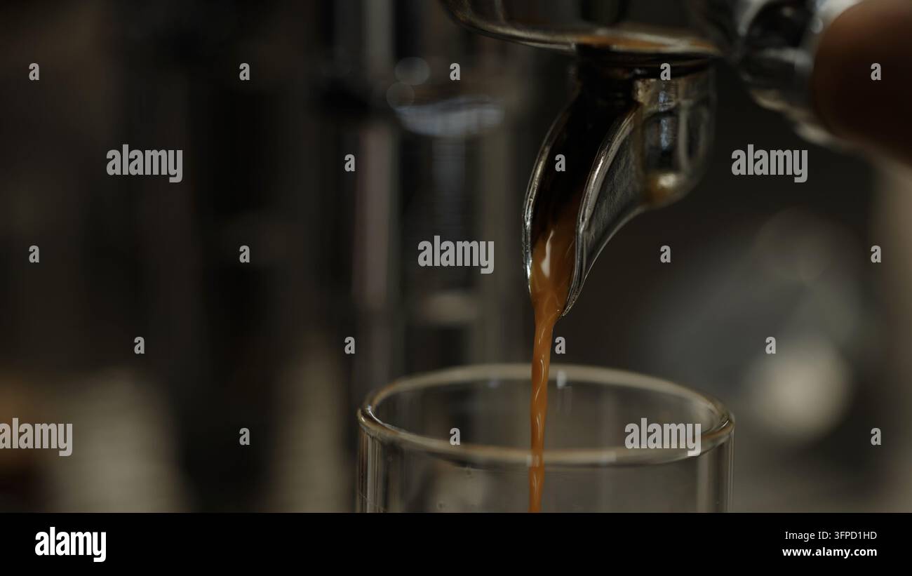 Prima piano dello tiraggio di un caffè espresso da una macchina da caffè Foto Stock