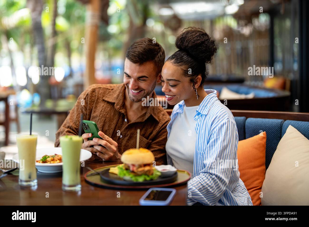 Coppia avventurosa che gusta cucina esotica mentre viaggia per il mondo, abbracciando nuove culture e cibo Foto Stock