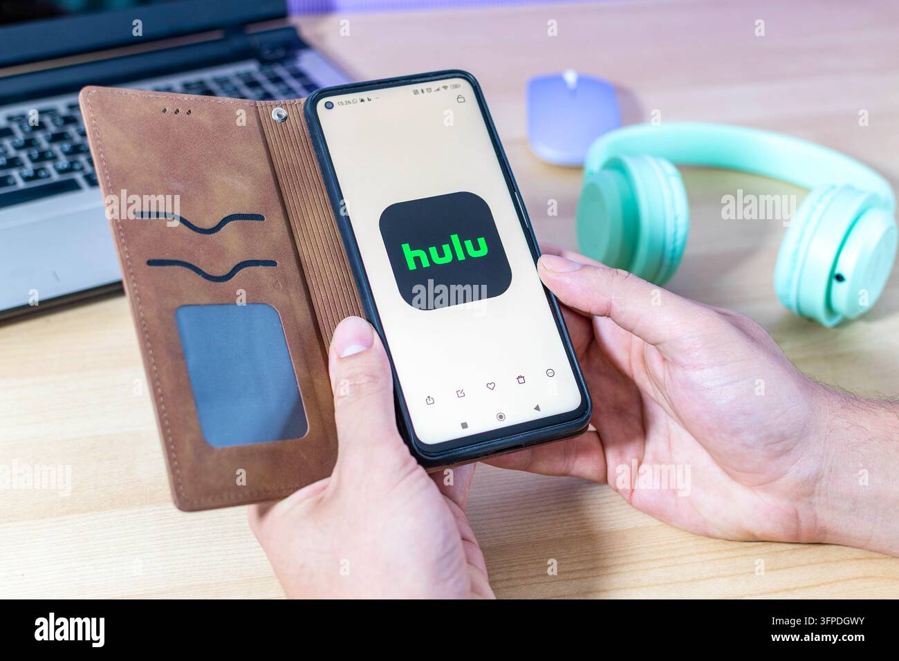 Mano che tiene uno smartphone con il logo dell'app Hulu. Foto Stock