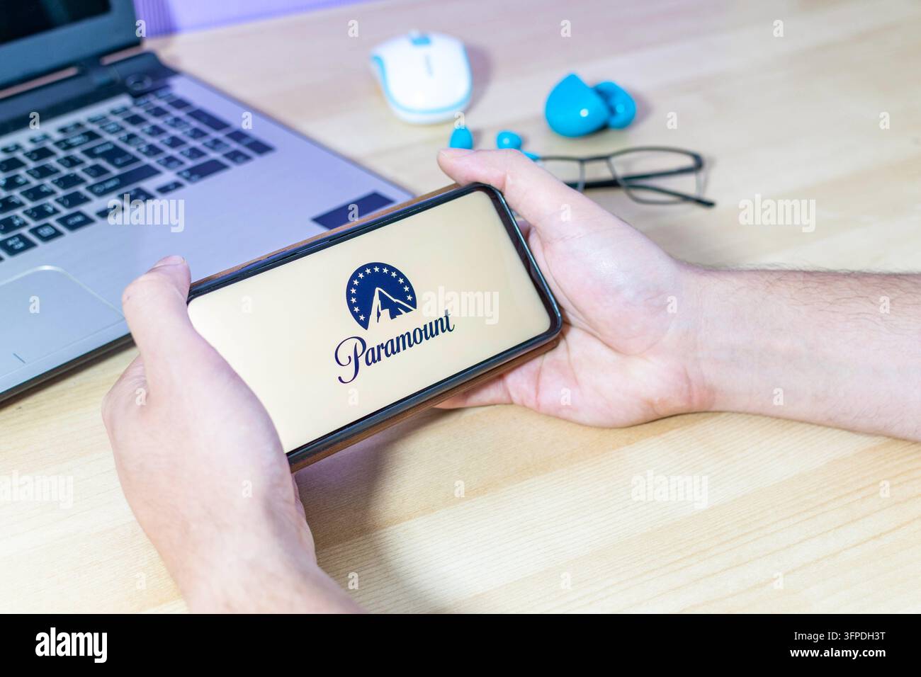 Mano che tiene uno smartphone con il logo Paramount. Foto Stock