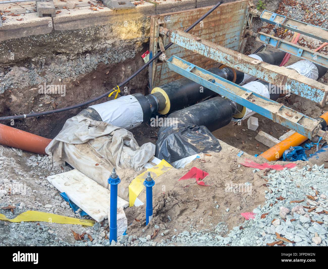 Lavori di ristrutturazione delle infrastrutture urbane di servizio con tubature scavate per riscaldamento, gas e acqua. Il progetto di costruzione mostra sotterraneo Foto Stock