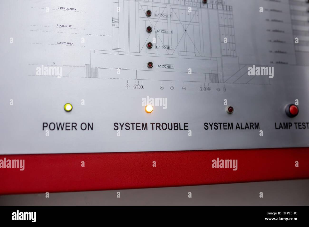 Pannello di controllo allarme con spie luminose POWER ON, SYSTEM TROUBLE, SYSTEM ALARM e pulsante di prova della lampada, diagramma delle zone dell'edificio su piastra metallica, cornice rossa Foto Stock