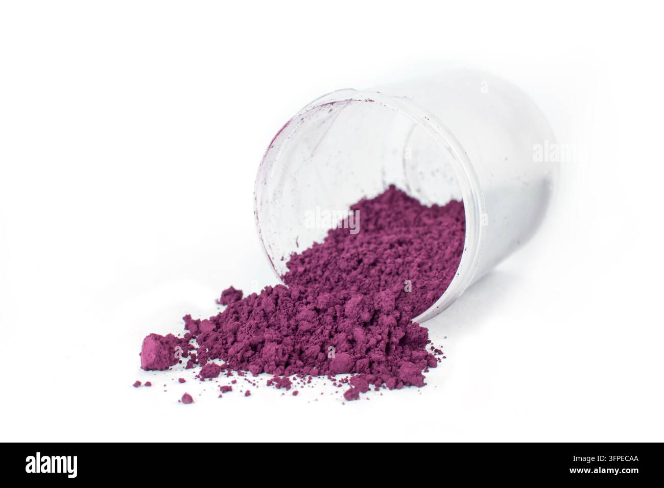 Un contenitore di vetro rovesciato, versando un pigmento viola brillante su una superficie bianca, mettendo in mostra la sua texture fine e il colore vivace. Caput Mortuum Foto Stock
