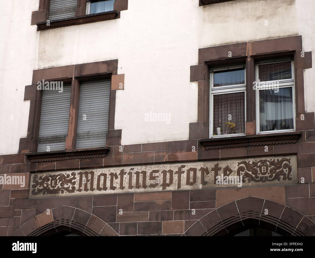 Iscrizione in caratteri gotici ornati che legge Martinspforte su una facciata in arenaria con decorazioni a volute a Worms, Germania. Foto Stock