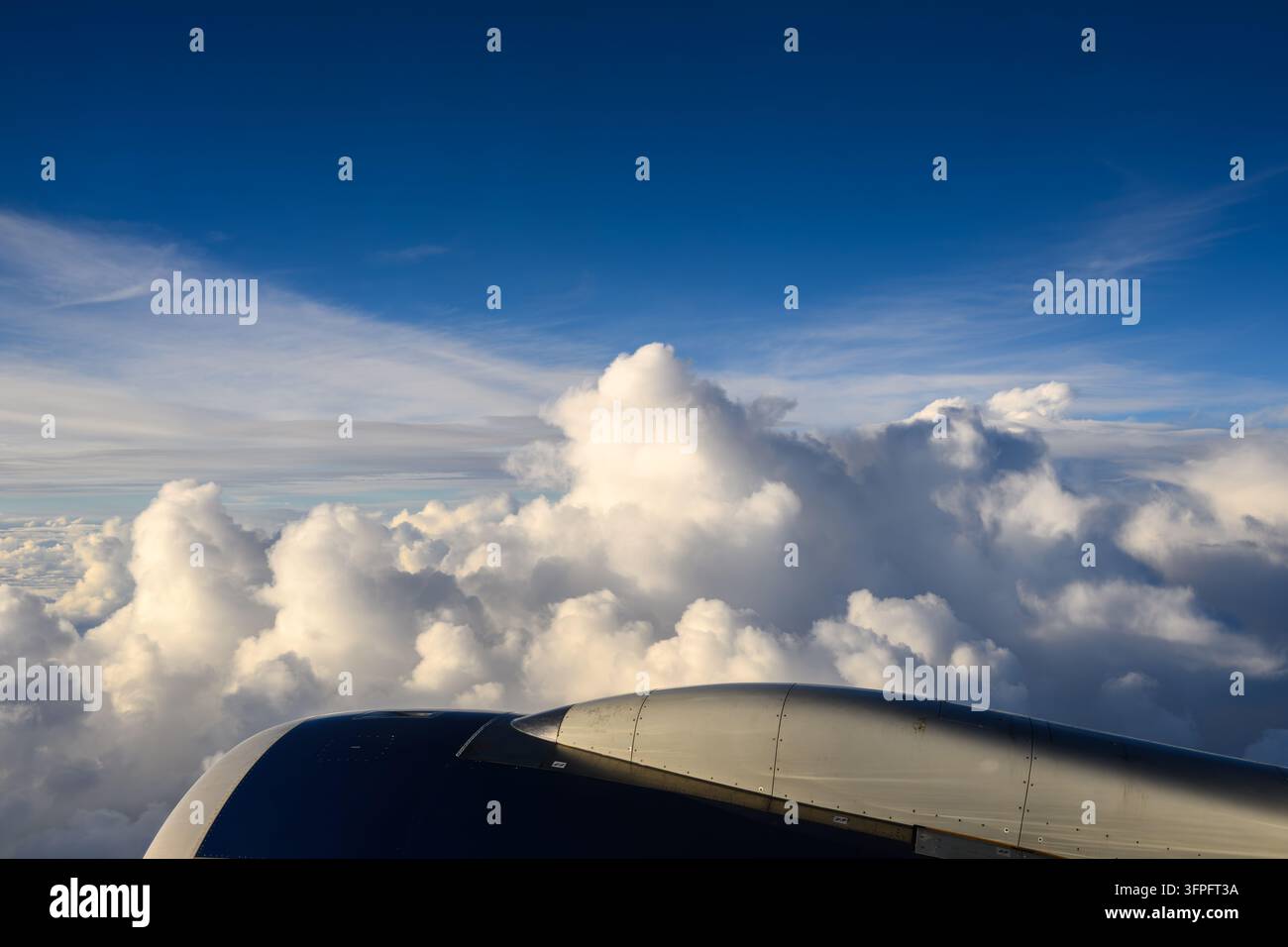 Cime delle nuvole che si dispiegano oltre il motore dell'aereo ad alta quota Foto Stock
