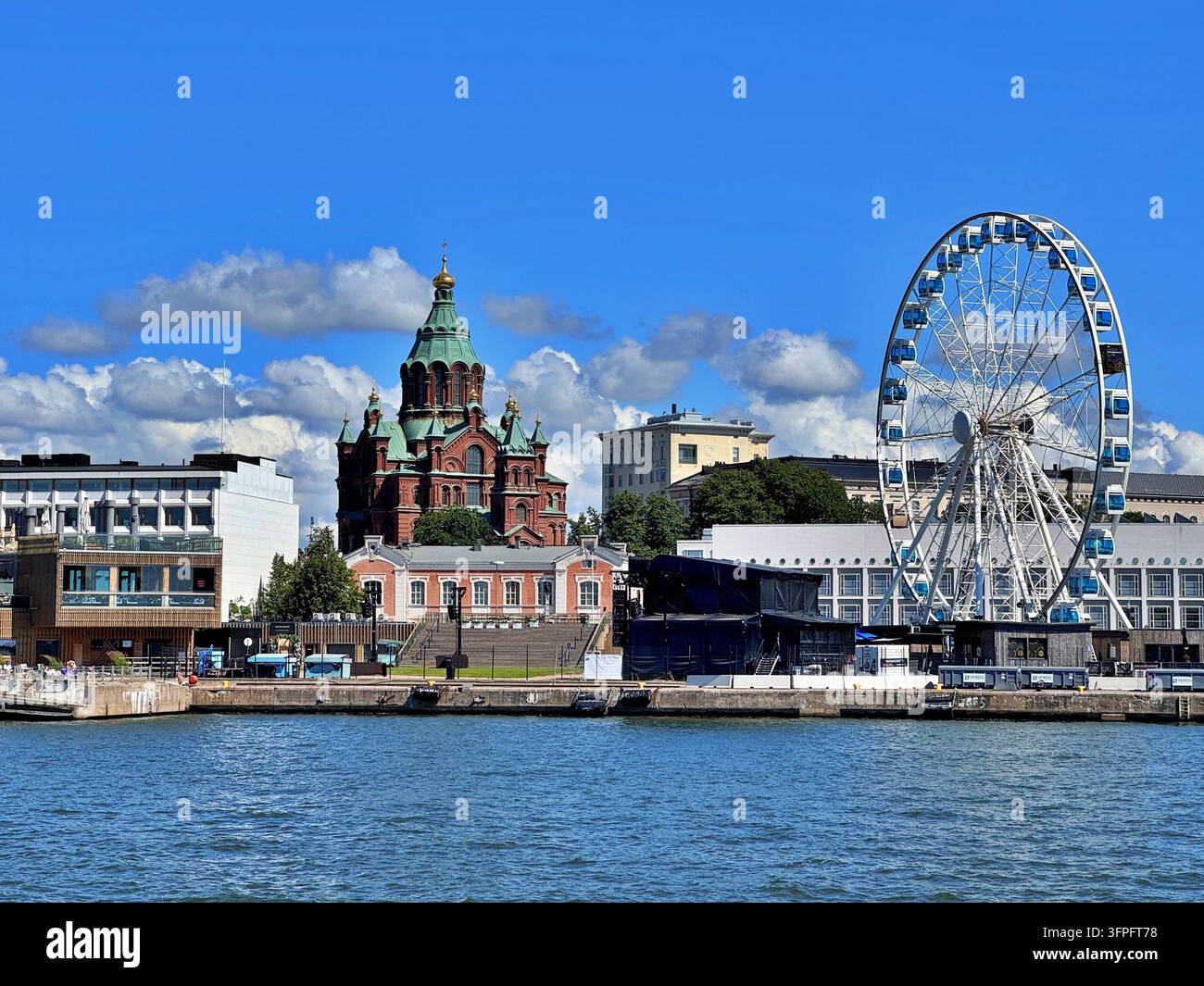SkyWheel Helsinki e la cattedrale Uspenski lungo il lungomare di Katajanokka, Helsinki, Finlandia, sotto un cielo estivo blu brillante. Foto Stock