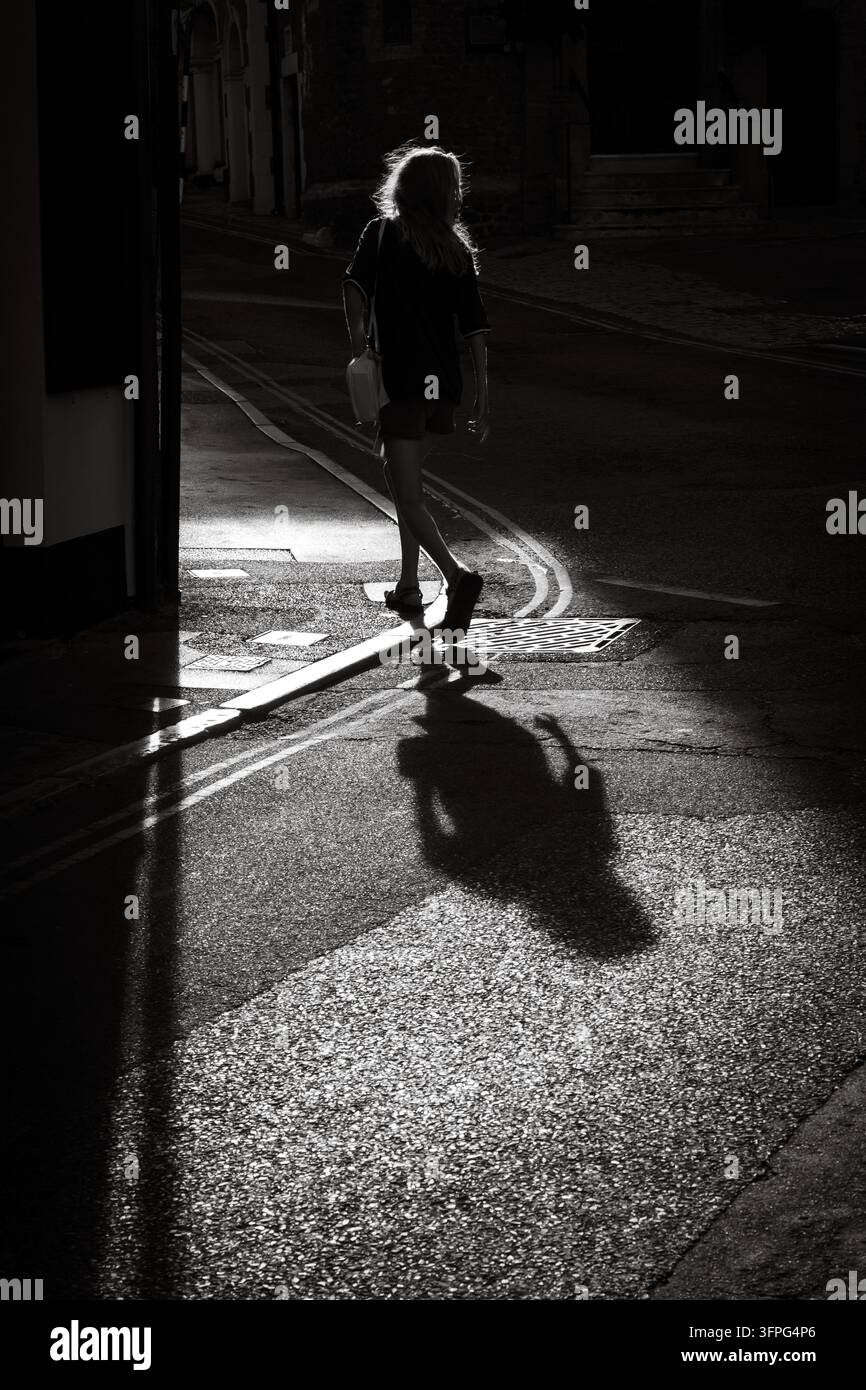 Donna che attraversa la strada Foto Stock
