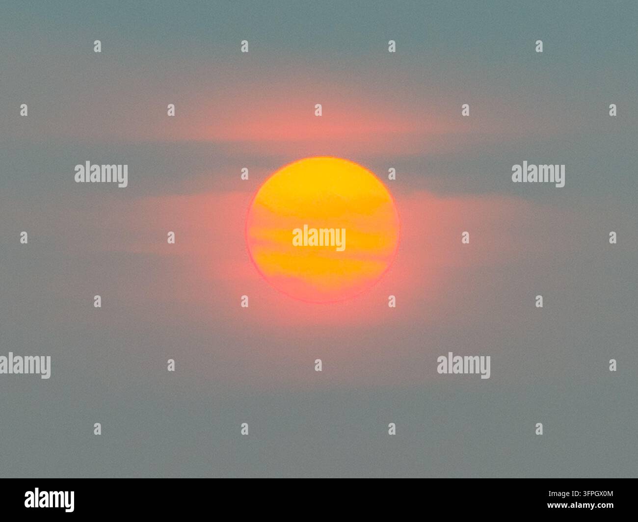 Il sole che tramonta illumina nuvole fosche in Indonesia. Foto Stock