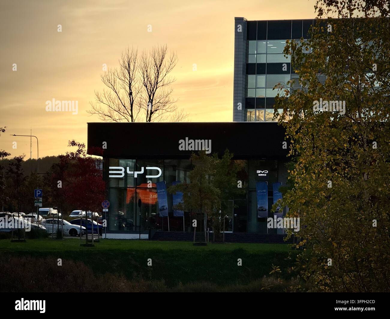 Un negozio di autovetture BYD moderno con un'insegna BYD bianca illuminata - Immagine stock catturata con smartphone