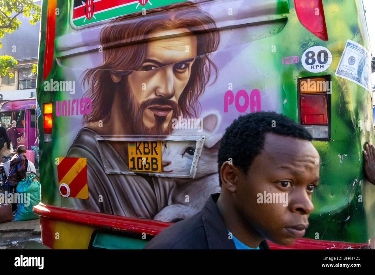 Retro di un matatu verde con una pittura airbrush di Gesù che tiene un agnello e un giovane uomo con una giacca nera che passa davanti, Contea di Nairobi, Nairobi Foto Stock
