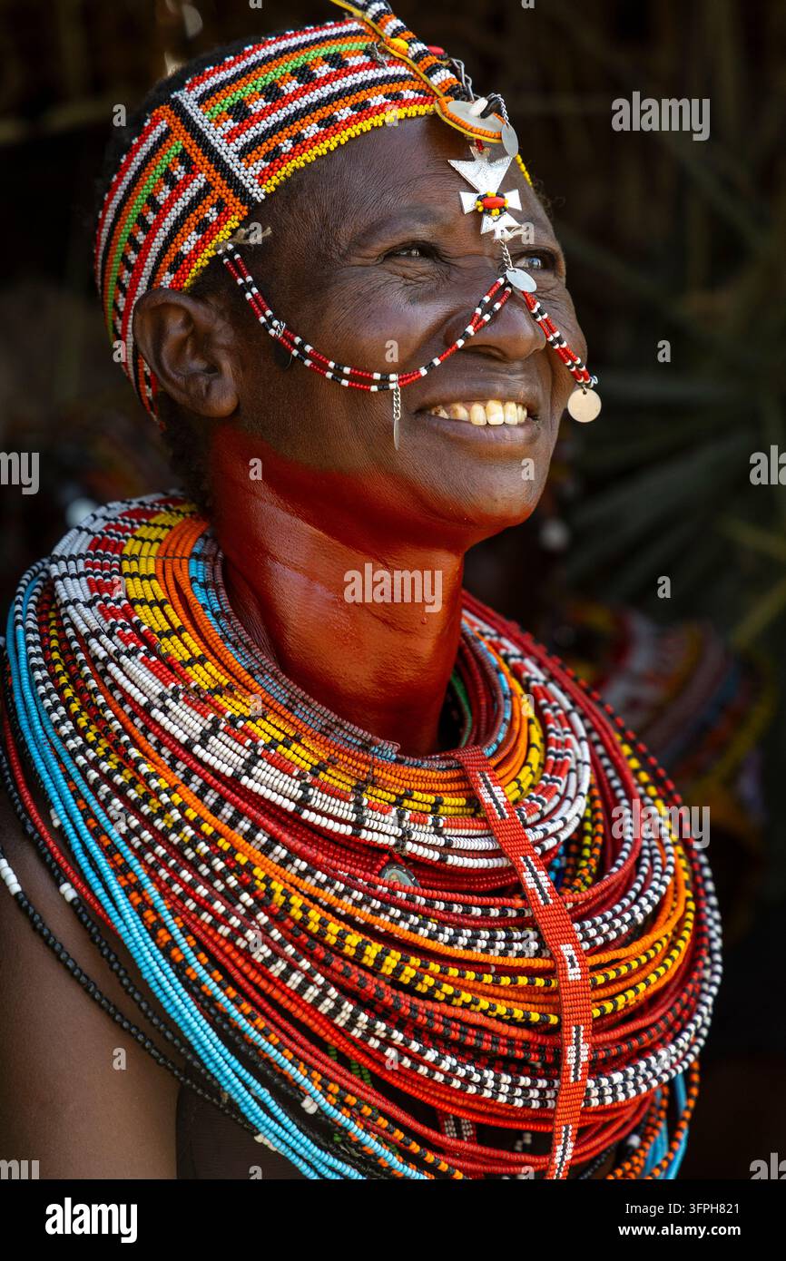 Donna sorridente della tribù Rendille con una fascia perlata e un ornamento a croce che indossa strati di collane perlate, Contea di Marsabit, Loiyangalani, Kenya Foto Stock