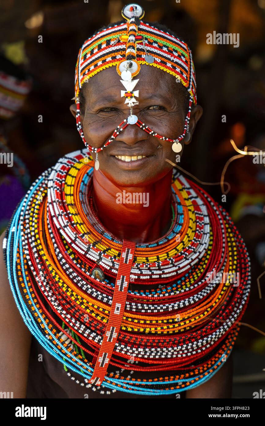 Donna sorridente della tribù Rendille con una fascia perlata con una croce d'argento e collane di perle impilate, Contea di Marsabit, Loiyangalani, Kenya Foto Stock