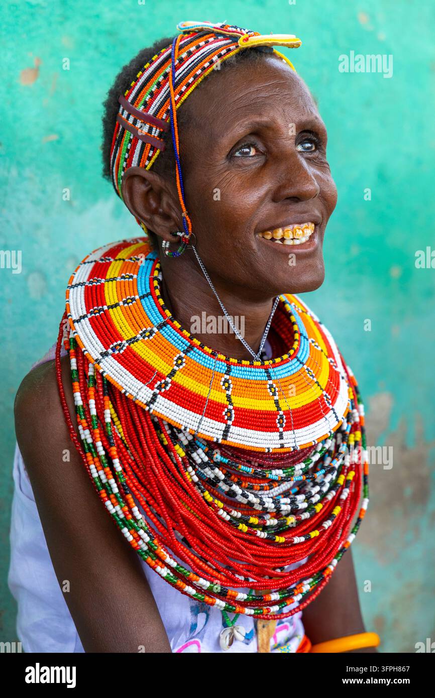 Donna sorridente della tribù Rendille che guarda verso l'alto indossando una fascia per capelli con perline e un grande collare di perline, Contea di Marsabit, Loiyangalani, Kenya Foto Stock