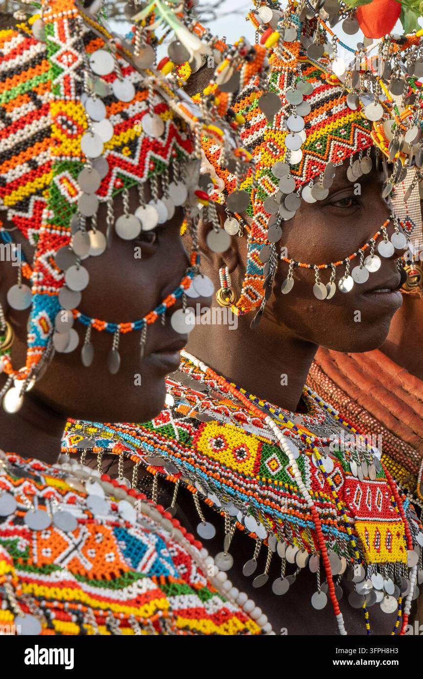 Primo piano del profilo di due donne della tribù Rendille con copricapo decorato con perline colorate e dischi d'argento pendenti e collane di perline a strati nella luce calda della sera Foto Stock