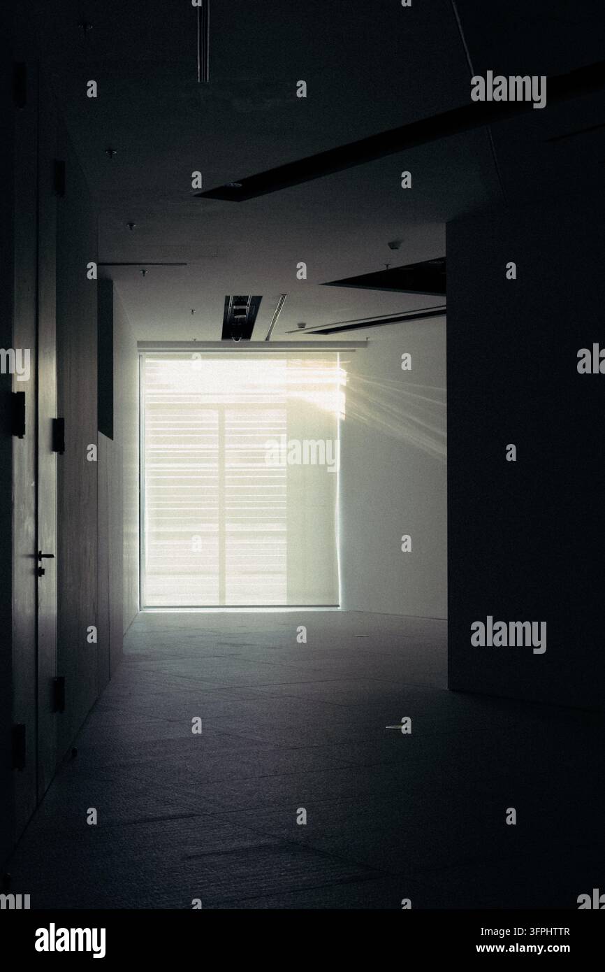 Interno di corridoio scuro con finestra luminosa alla fine Foto Stock