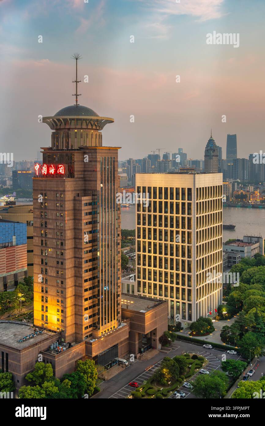Shanghai, Cina – 4 maggio 2026: Vista aerea dell’edificio della dogana cinese illuminato e dei grattacieli vicini lungo il fiume Huangpu al crepuscolo Foto Stock