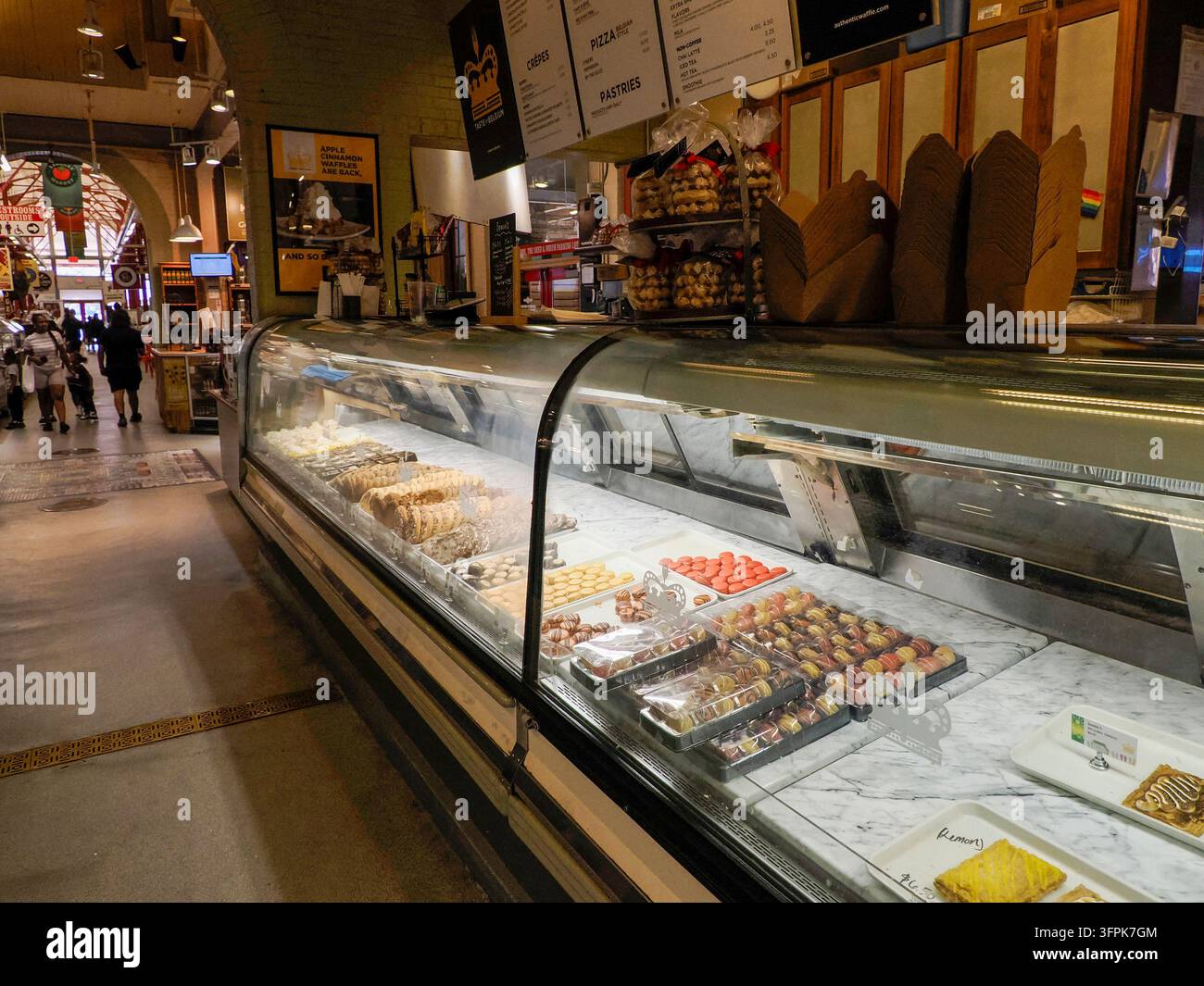 CINCINNATI, USA - 29 AGOSTO 2024: Vetrina curva in vetro piena di macarons colorati, cioccolatini e prodotti da forno in una negozio di waffle belgi Foto Stock