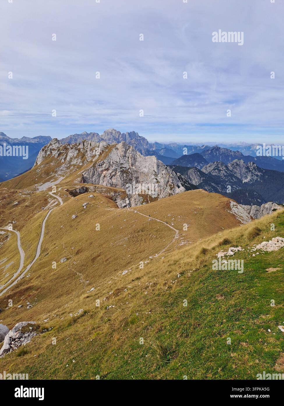 Cresta montuosa erbosa con sentiero e picchi rocciosi, Alpi Giulie Foto Stock