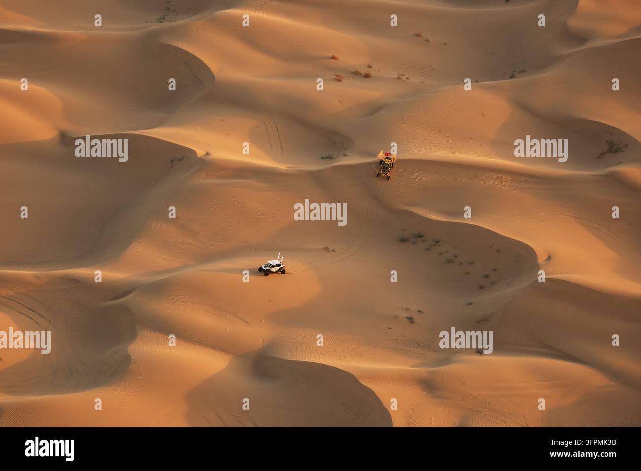 Vista aerea di veicoli fuoristrada che attraversano le vaste dune di sabbia dorata delle Imperial Sand Dunes nel paesaggio desertico di Glamis, California, Stati Uniti Foto Stock