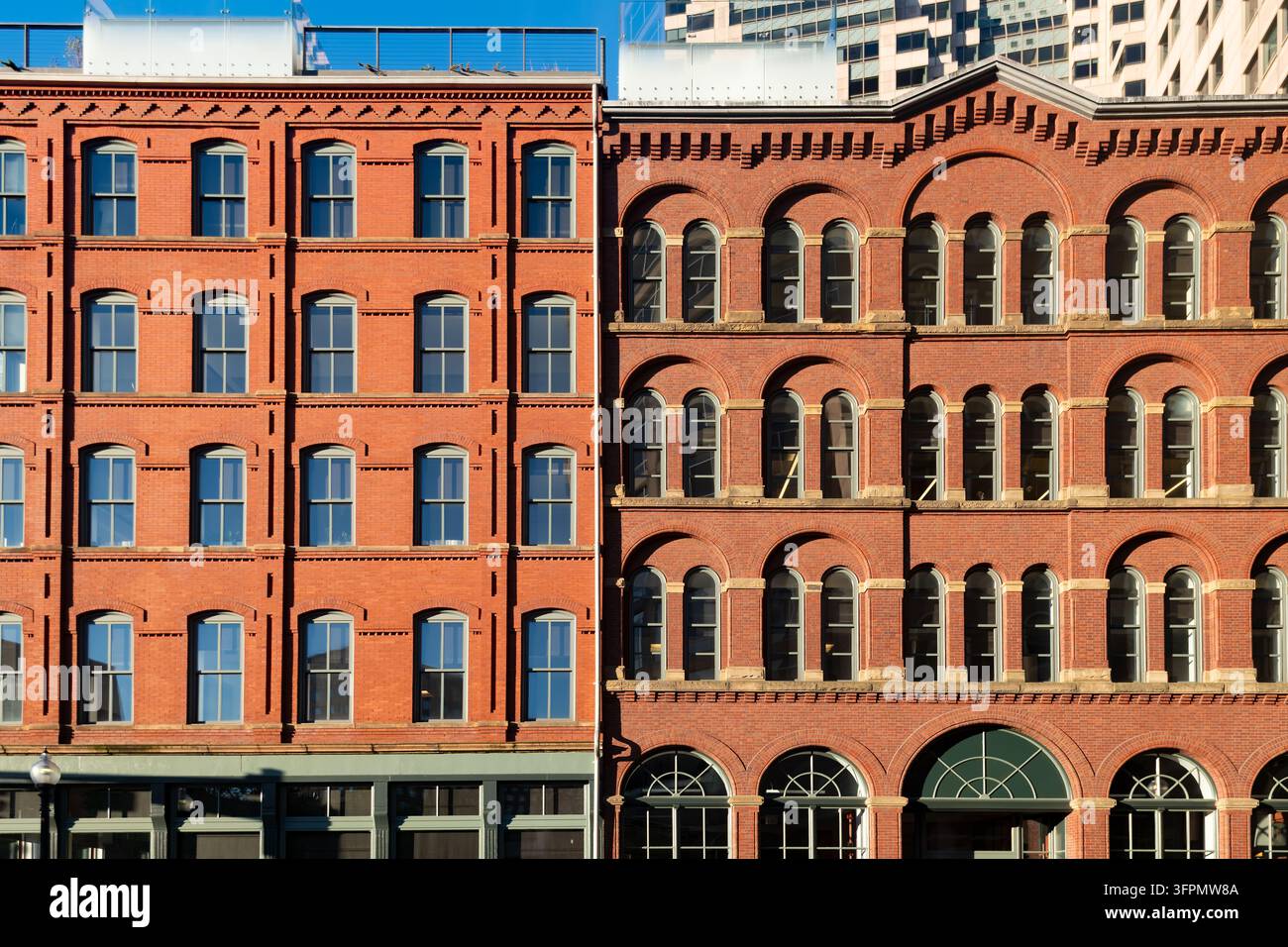 Facciate in mattoni rossi nel centro di Boston, Massachusetts, Stati Uniti, con file di finestre ad arco, muratura decorativa e decorazioni in pietra. Foto Stock