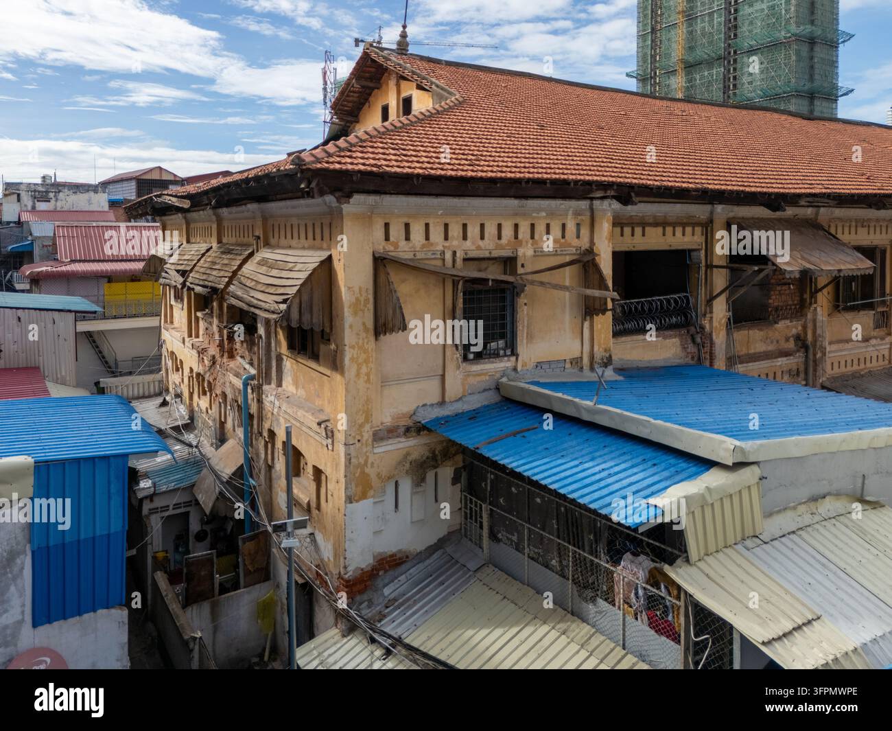 Vista aerea dell'antica architettura coloniale con pareti gialle consumate e tegole di terracotta nel centro cittadino di Phnom Penh, Phnom Penh, Cambogia. Foto Stock