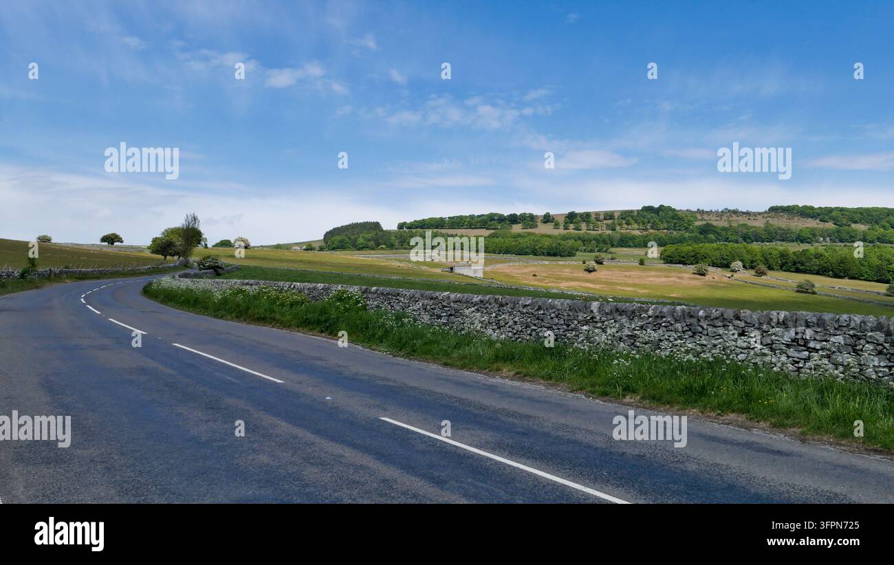 Strada chiara con un muro di pietra accanto nel Peak District Foto Stock