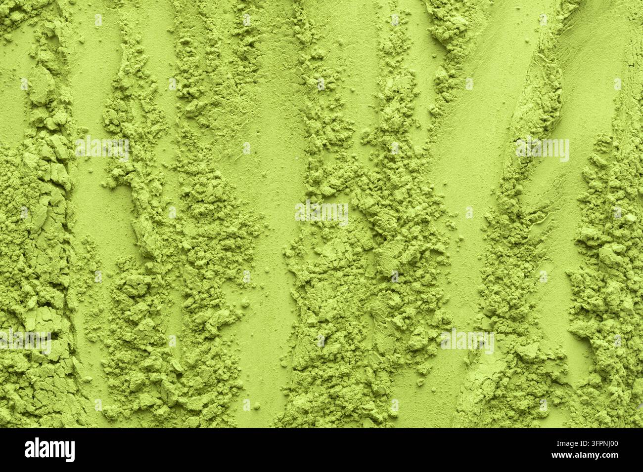 Linee verticali e ammassi di polvere di tè matcha creano una superficie strutturata ma organica, ideale per i concetti visivi moderni di cibo e benessere. Foto Stock
