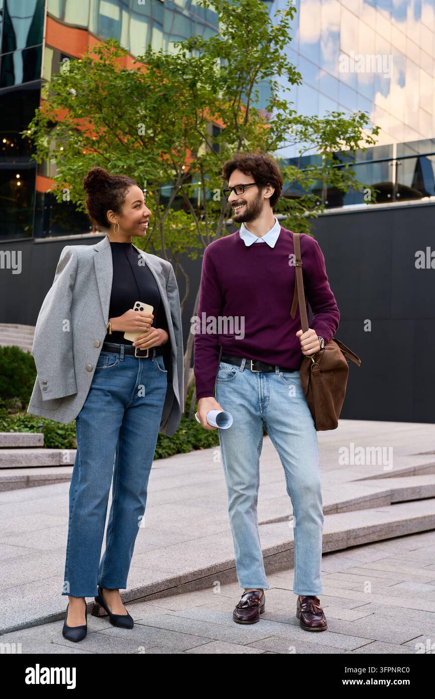 Un agente immobiliare discute i dettagli della proprietà con un cliente afroamericano all'aperto Foto Stock