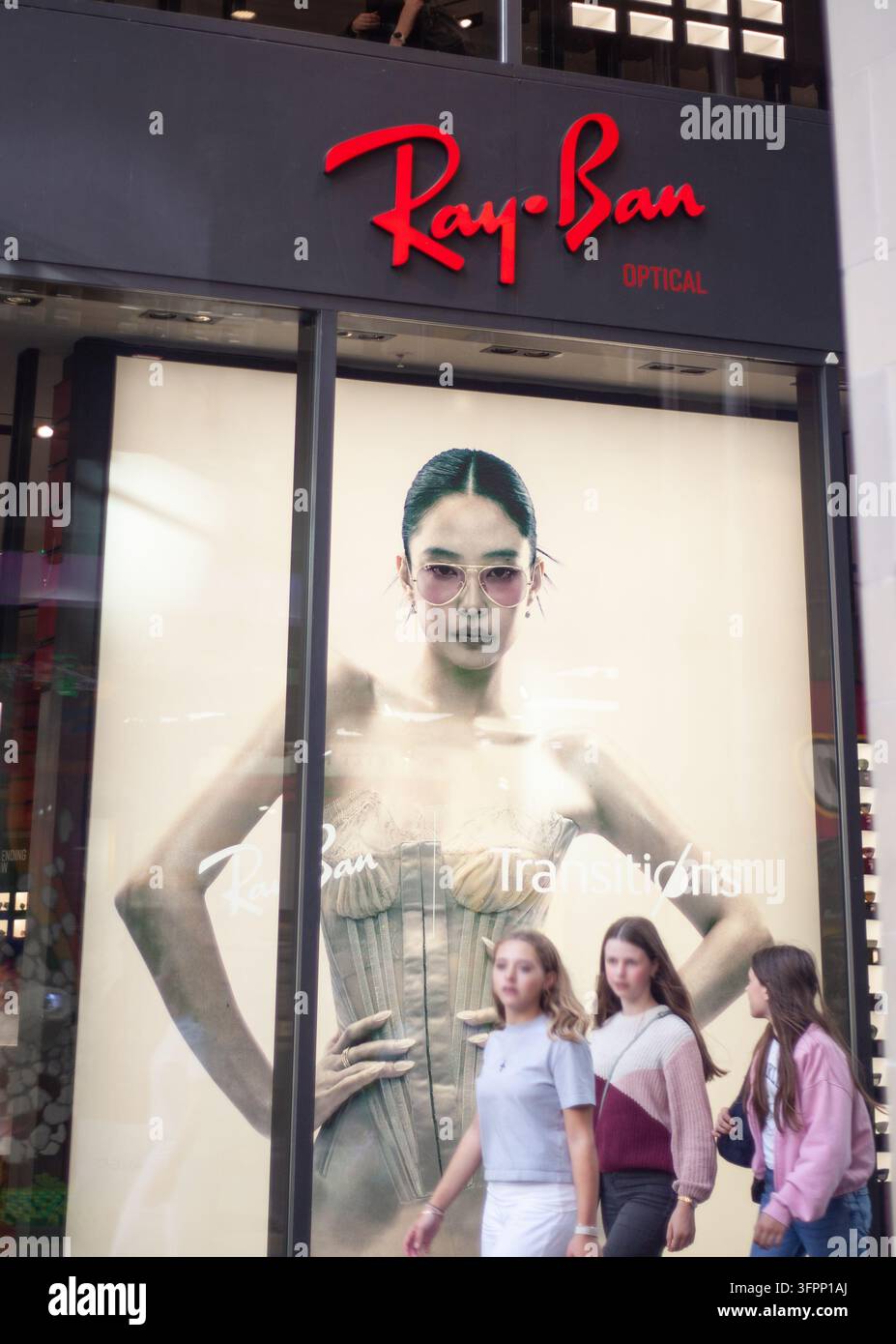 La vetrina luminosa e le lettere del logo aziendale della boutique di occhiali di lusso Ray-Ban nel centro città di Monaco di Baviera, Germania. Foto Stock