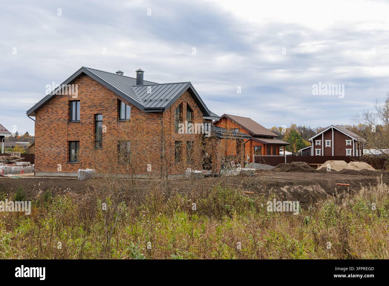 Cottage di classe premium appena costruito con facciata in mattoni di clinker e tetto in metallo in fase di sviluppo nel Nord Europa. Foto Stock