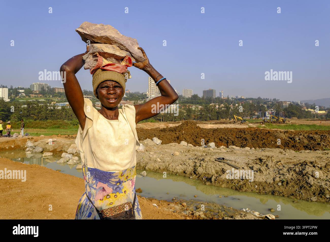 Lavoratore che trasporta blocchi in cantiere a Kigali, Ruanda Foto Stock