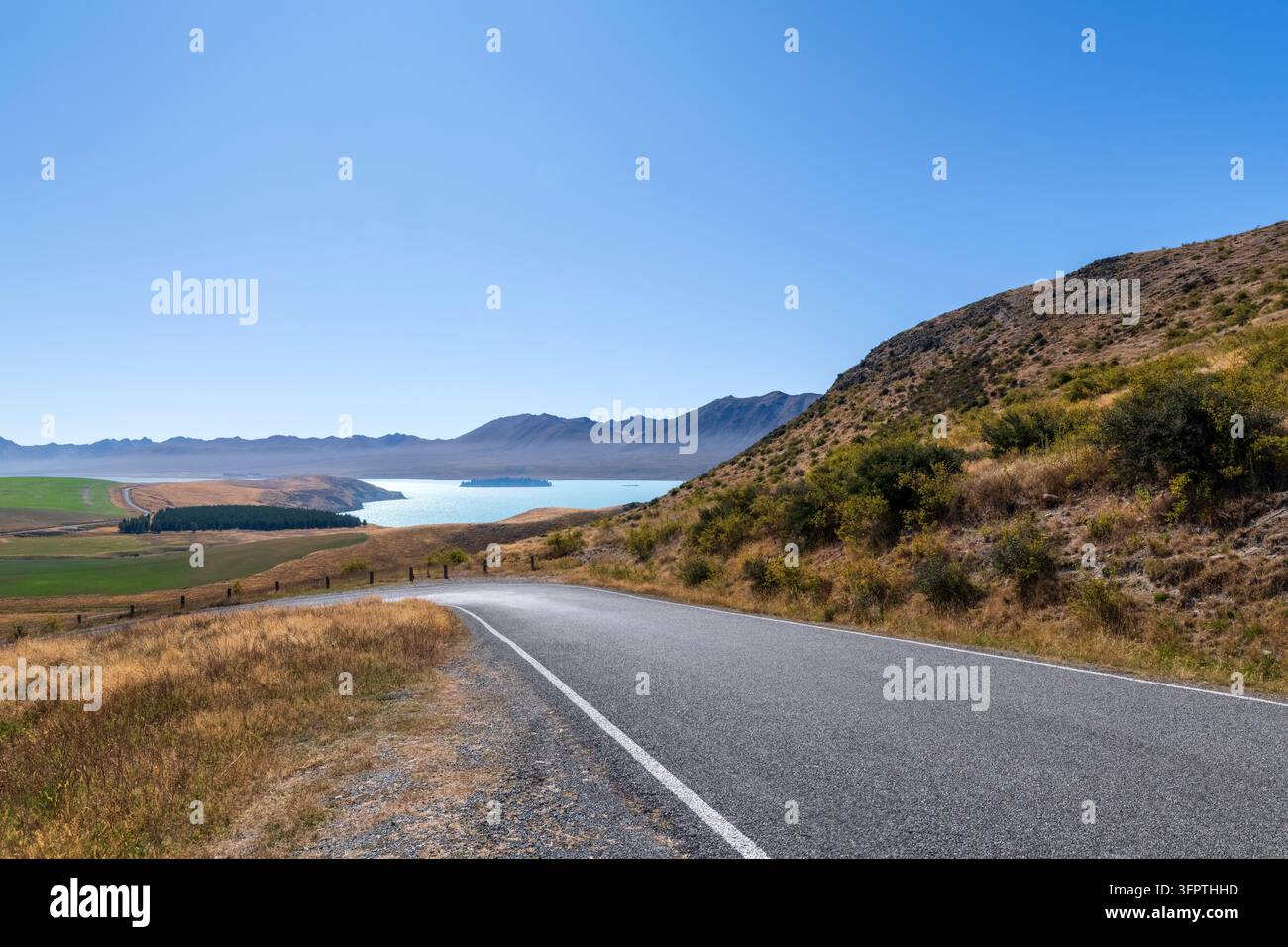 Sfondo stradale, piastra posteriore automobilistica, curva a gomito lastricata in un paesaggio rurale aspirazionale con vedute estese Foto Stock