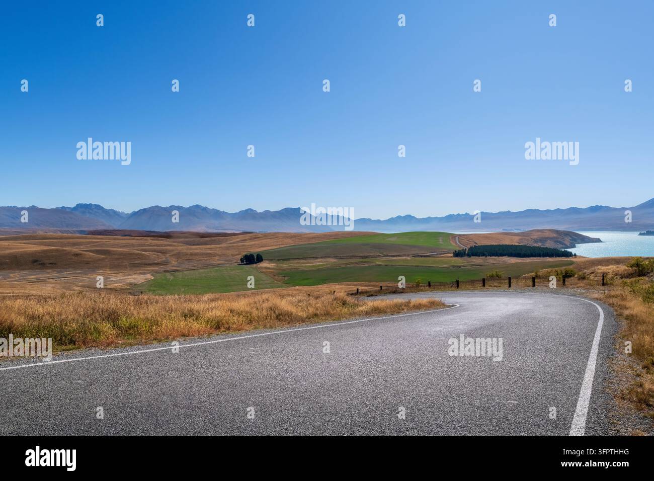 Sfondo stradale, piastra posteriore automobilistica, curva a gomito lastricata in un paesaggio rurale aspirazionale con vedute estese Foto Stock