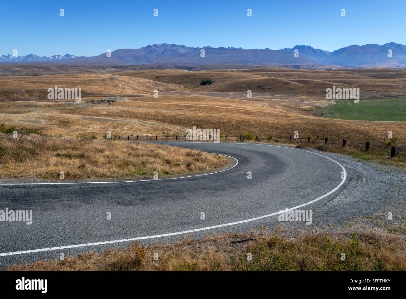 Sfondo stradale, piastra posteriore automobilistica, curva a gomito lastricata in un paesaggio rurale aspirazionale con vedute estese Foto Stock