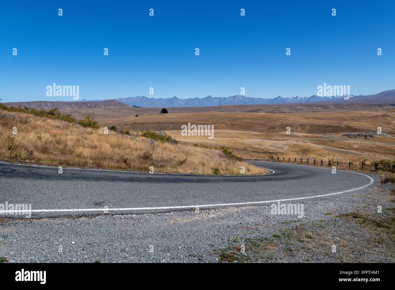 Sfondo stradale, piastra posteriore automobilistica, curva a gomito lastricata in un paesaggio rurale aspirazionale con vedute estese Foto Stock