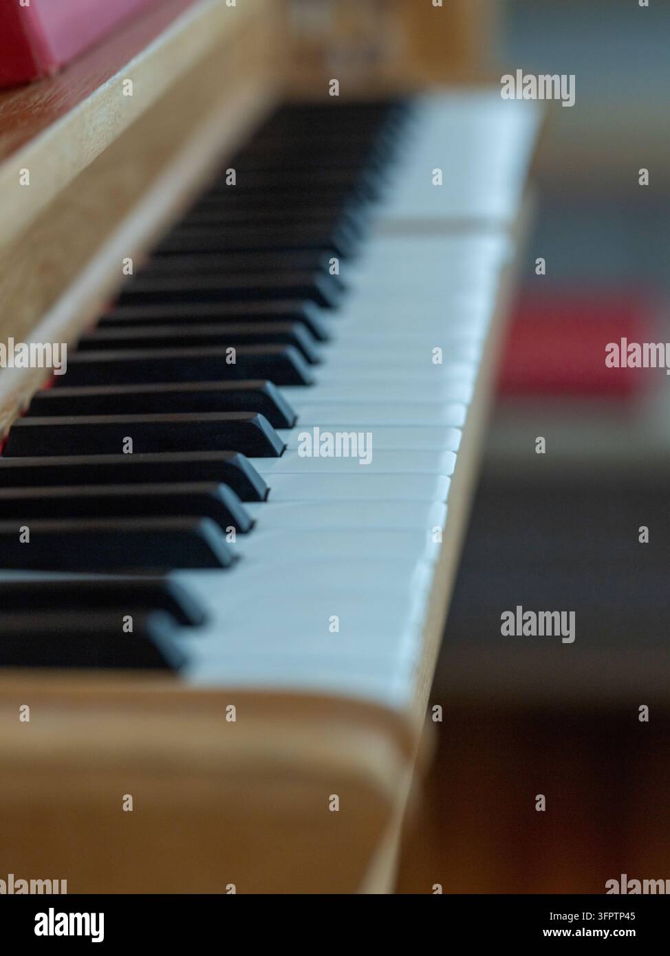 Primo piano dei tasti bianchi e neri di un pianoforte all'interno della chiesa di Puottaure nel nord della Svezia, fotografato con poca profondità di campo. Foto Stock