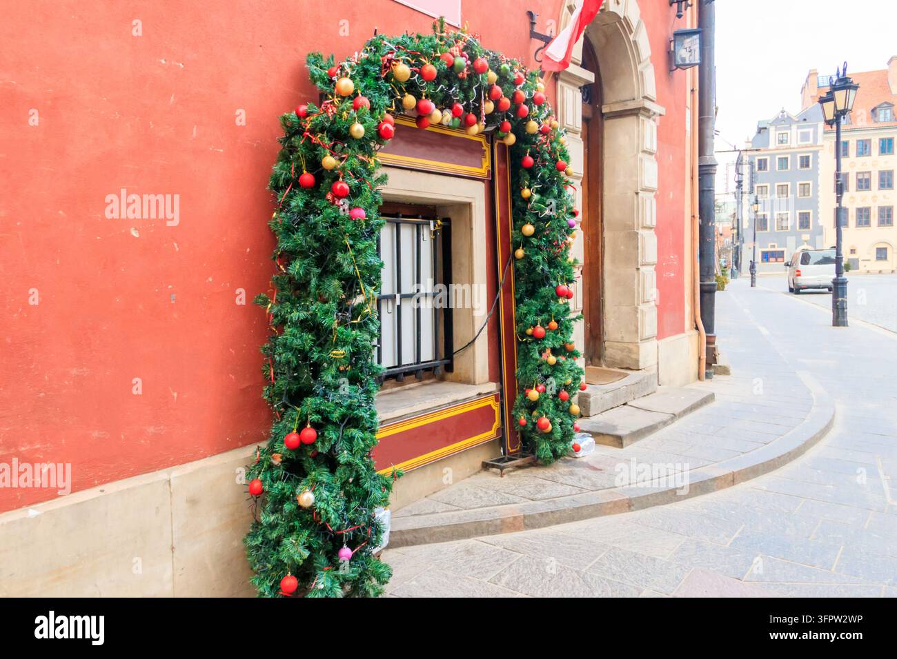 Finestra decorata con un arco di ghirlanda verde natalizia Foto Stock