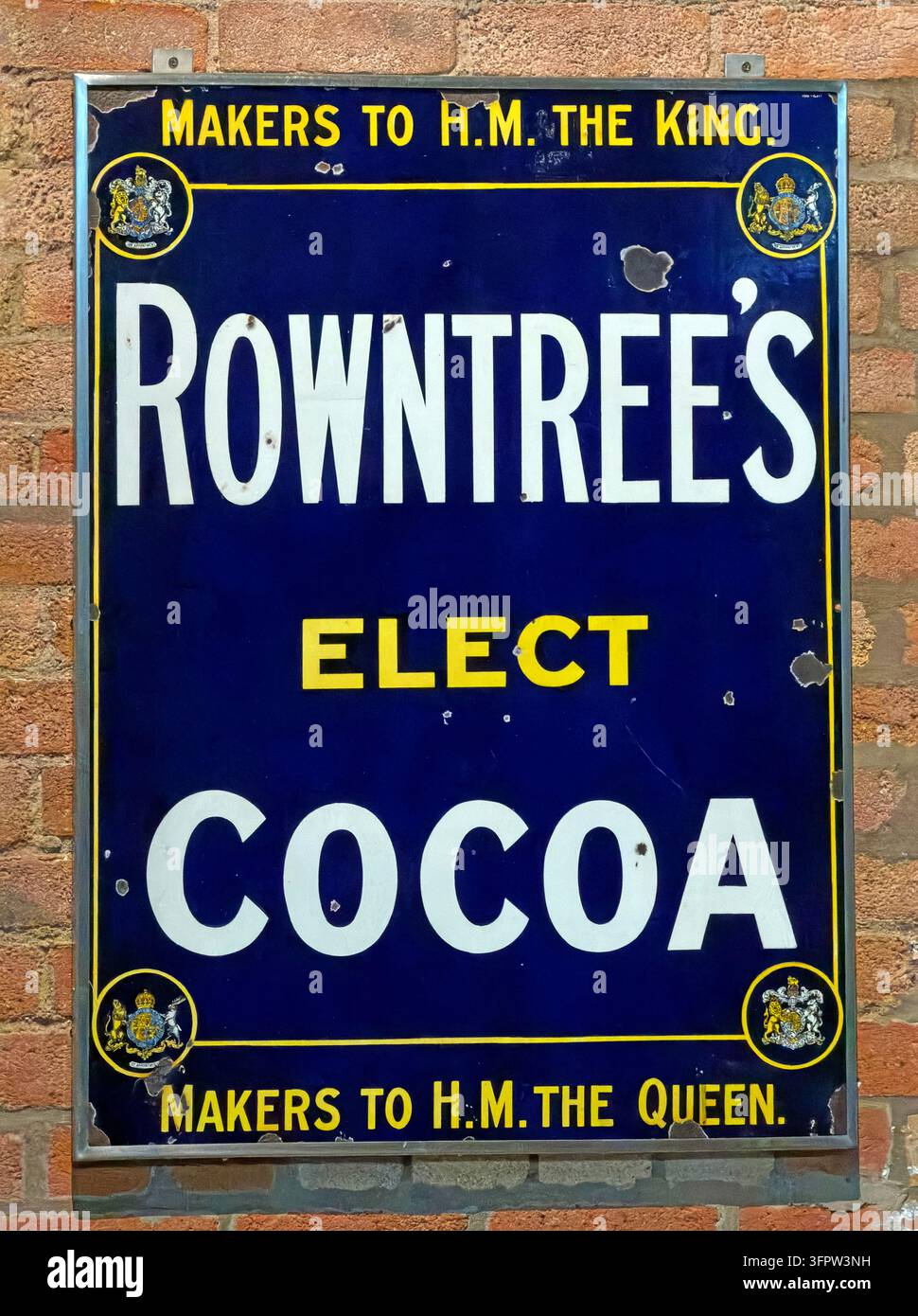 Un cartello pubblicitario vintage in smalto blu Rowntree’s Elect Cocoa proclama lo status di fornitore reale dell'azienda. Foto Stock
