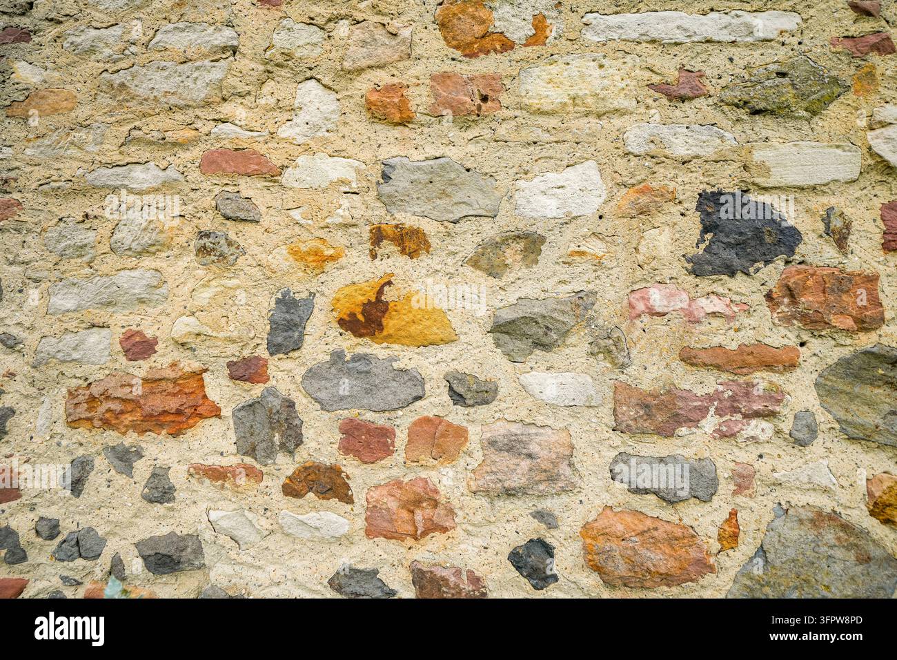 Primo piano di un muro di pietra rustico in una rovina. Sfondo con un muro di pietra antico. Foto Stock